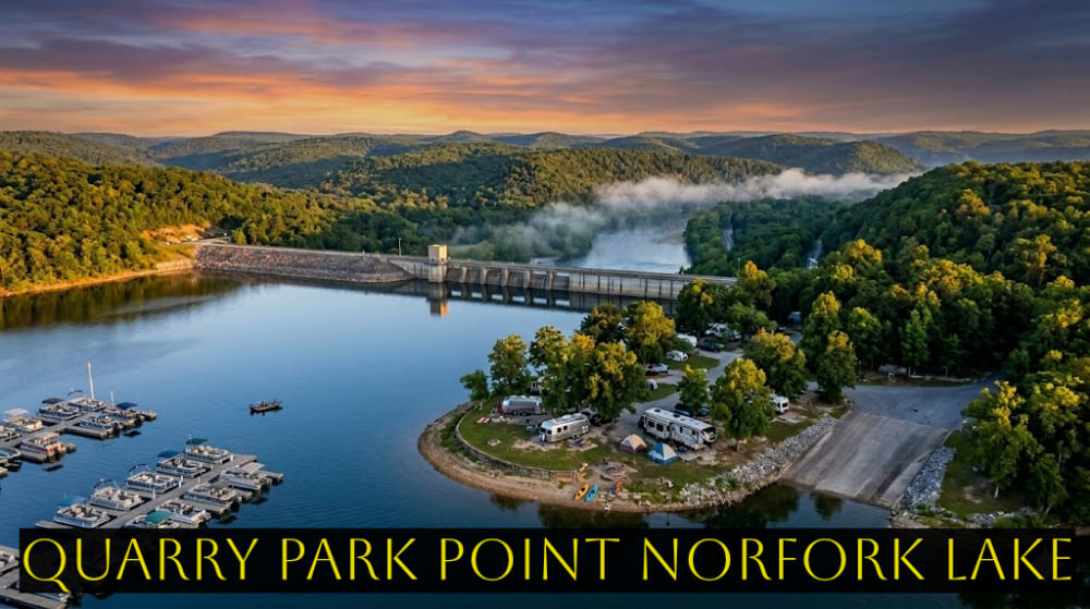 An ultra-realistic aerial panoramic view of Quarry Park Point on Norfork Lake at sunset. The image shows the Dam Quarry Campground on a peninsula with Airstream trailers, RVs, and tents, a large marina with pontoon boats, the Norfork Dam spanning the background river, and dense forested Ozark mountains under a warm sky.